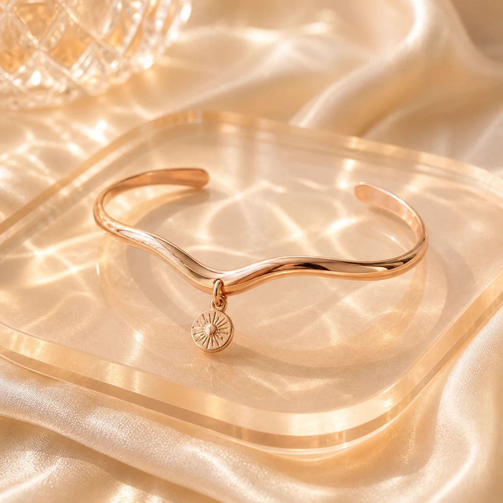 Rose-gold wave cuff bracelet with a small sunburst charm